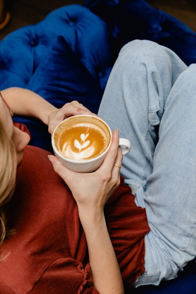 Woman hold coffee while reclining in seat